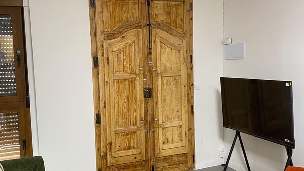 A room with a wooden door, a music stand, a table, and a green sofa. - 1BR near Malvarrosa beach Cabanyal R53 (Valencia / València)