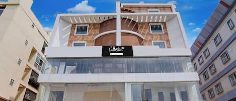 A multi-story building with a prominent 'Collection' sign, large windows, and a visible staircase leading to the entrance.