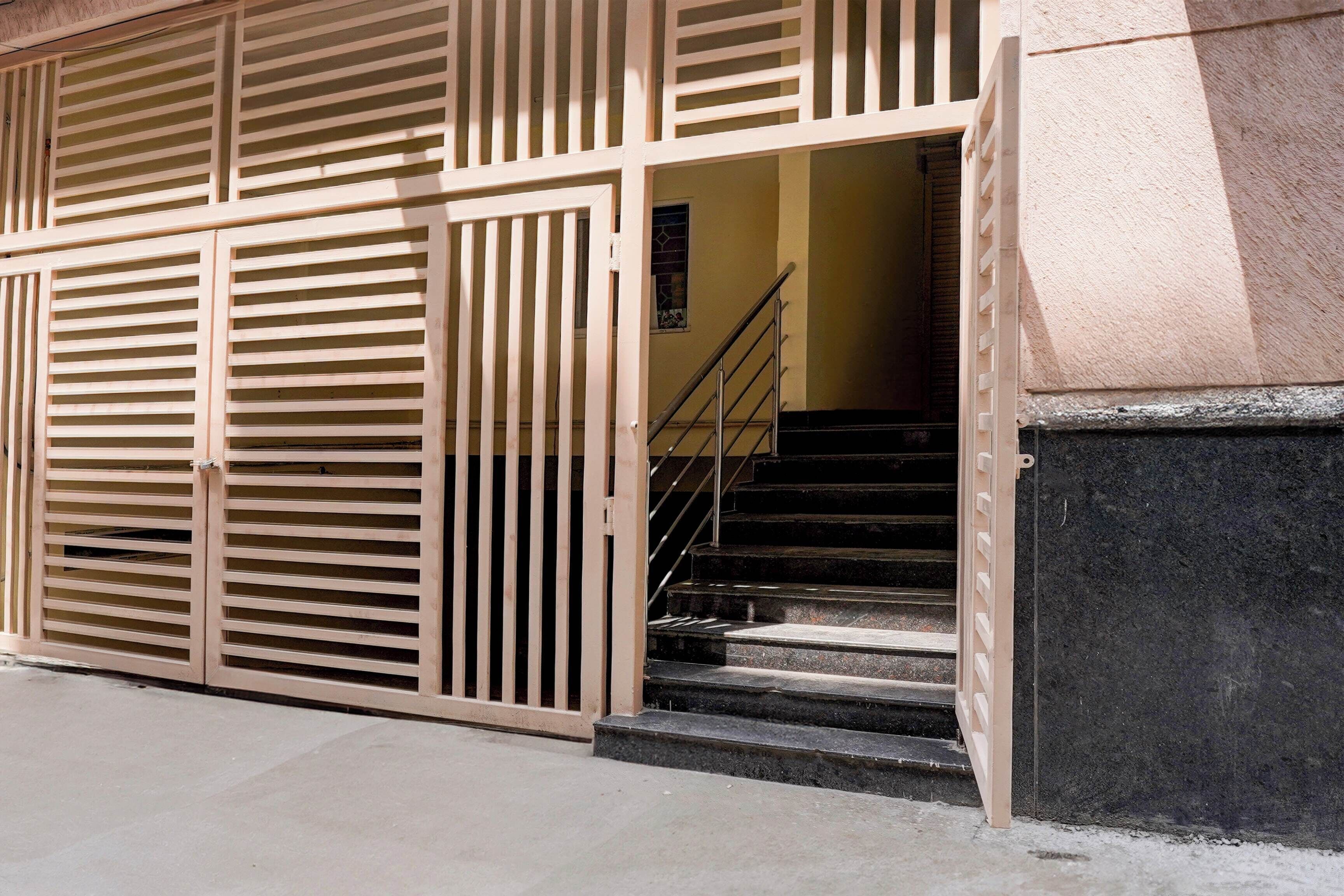 Entrada de un edificio con una escalera que lleva a un nivel superior.