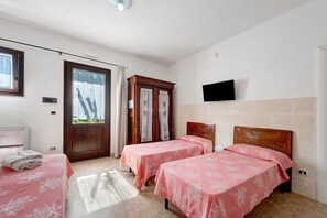 A hotel room with two beds, a television, a wardrobe, and a window with curtains. - Fico d'India Room (Porto Cesareo)