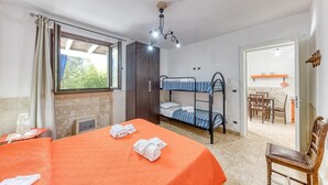 Een kamer met stapelbedden, een eettafel en een open haard.