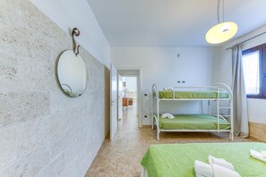 Una stanza con letti a castello, uno specchio e una lampada a sospensione.