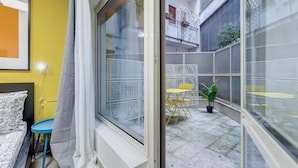 A room with a bed, a small table, and a window.