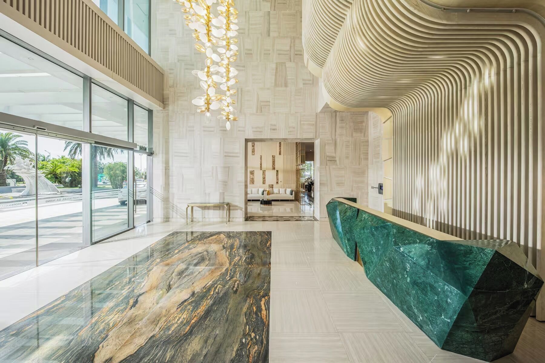 Un moderno vestíbulo con un mostrador de recepción de mármol, un banco y una pared con diseño.