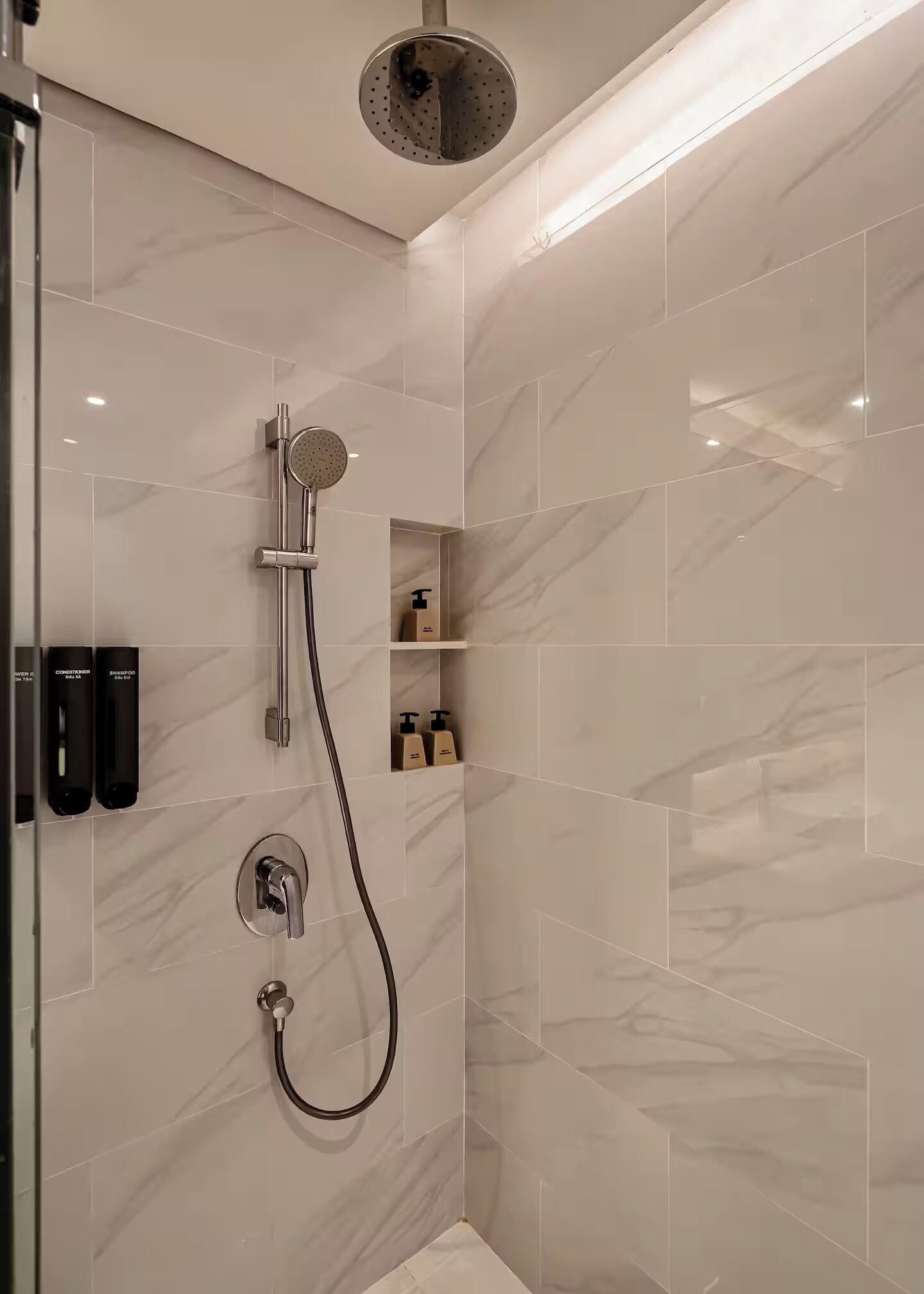 Ducha moderna con cabezal de ducha de mano y grifo empotrado.
