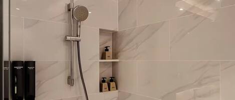 Ducha moderna con cabezal de ducha de mano y grifo empotrado.