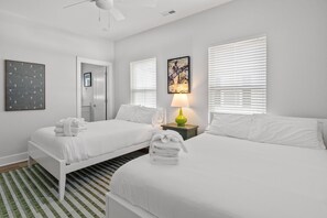 A hotel room with two beds, a bathroom, a door, and a window with blinds. - The Golden Tee Pet Friendly 2.5 Blocks to Beach (Myrtle Beach)