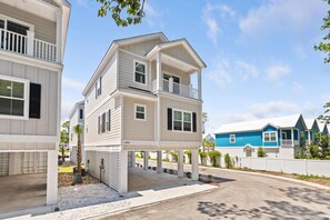A multi-story residential building with a balcony, a driveway, and a neighboring house. - The Golden Tee Pet Friendly 2.5 Blocks to Beach (Myrtle Beach)