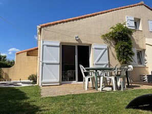 A house with a patio, a sliding glass door, and outdoor furniture.