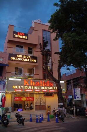 A building with signage for 'SRS TOWERS' and 'SRI SIVA SHANKARA INN' on the upper floors, and 'Khalids MULTICUISINE RESTAURANT' on the ground floor.