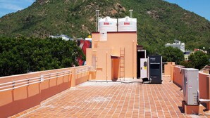 A rooftop terrace with a view of a mountain, a water tank, and a power unit. - Sri Siva Shankara Inn (Tiruvannamalai)