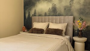 A bedroom with a large bed, a headboard, a nightstand, and a wall mural. - Green Pine Studio Hils Brauner - Free Parking - Nearby Metro Station (București)