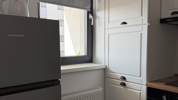 A kitchen with a built-in water dispenser, a window with a blind, and a stove. - Green Pine Studio Hils Brauner - Free Parking - Nearby Metro Station (București)