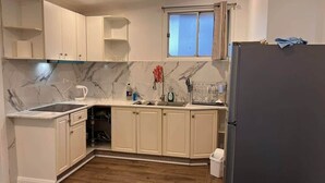 Una cocina con armarios blancos, un salpicadero de mármol y un horno empotrado.
