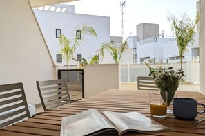 A balcony with a wooden table, two chairs, a book, a glass of orange juice, and a vase with flowers. - SUNNY HILLS dream apartment (Finestrat)