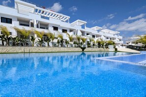 A modern hotel with a swimming pool, white architecture, and palm trees. - SUNNY HILLS dream apartment (Finestrat)