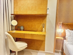 A hotel room with a wooden desk, a chair, a bedside table with a lamp, and a bed. - Modern Apartment • 7-minute subway ride • Paris (Joinville-le-Pont)