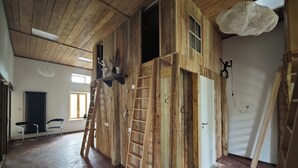 A room with wooden walls, a ladder, and a hanging light fixture. - Domaine du Moulin Français - Outdoors (Champougny)