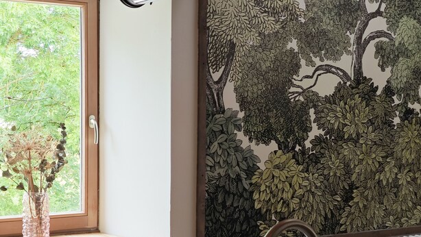 A modern kitchen with a wooden ceiling, a window with a view of trees, a radiator, and a sink with a faucet. - Domaine du Moulin Français - Outdoors (Champougny)