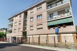 A multi-story residential building with balconies, a gated entrance, and a visible laundry hanging outside. - Aaron Guest House - 4-Bedroom Apartment in Marghera (Venice)