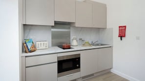 A modern kitchen with a built-in oven, a microwave, and a toaster. - Student Only Waterloo House (York)