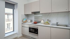 A modern kitchen with a built-in oven, a toaster, a kettle, and a sink. - Student Only Waterloo House (York)