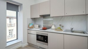 Eine moderne Küche mit Einbauofen, Toaster, Wasserkocher und Spüle.