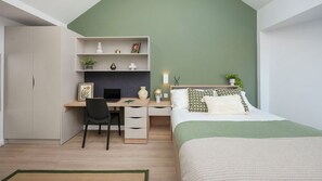 Ein Schlafzimmer mit einem Bett, einem Schreibtisch mit Stuhl, einem Kleiderschrank und einem Regal mit Dekoration.