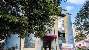 A modern building with a glass facade, a red awning, and a sign indicating 'Collection' and 'Skanda Shelters'. - Collection O Bannerghatta Road (Bengaluru)