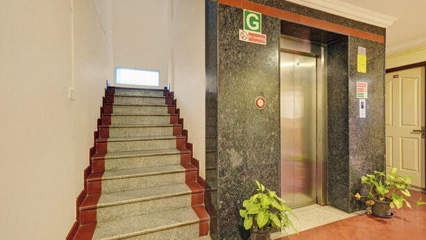 A hotel lobby with a staircase, an elevator, and a door marked with the number 108. - Collection O Bannerghatta Road (Bengaluru)