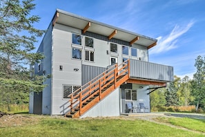 A modern two-story building with a wooden staircase and large windows.
