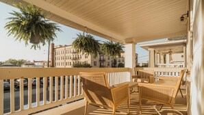 A balcony with wicker furniture, hanging plants, and a view of the street. - Modern Ocean City 2-unit Home Near Dtwn & Beach! (Ocean City)
