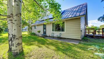 A single-story house with a front porch, a small garden, and a metal roof.