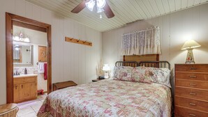 A bedroom with a bed, dresser, vanity, and a ceiling fan. - Charming Resort Cabin at Lake Hiwassee! (Murphy)