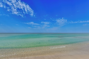 A beach with clear turquoise water and a sandy shore. - Steps to Beach! 2-unit Combo w/ Pool Access in PCB (Panama City Beach)
