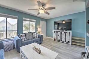 A living room with a sofa, coffee table, and a ceiling fan. - Steps to Beach! 2-unit Combo w/ Pool Access in PCB (Panama City Beach)