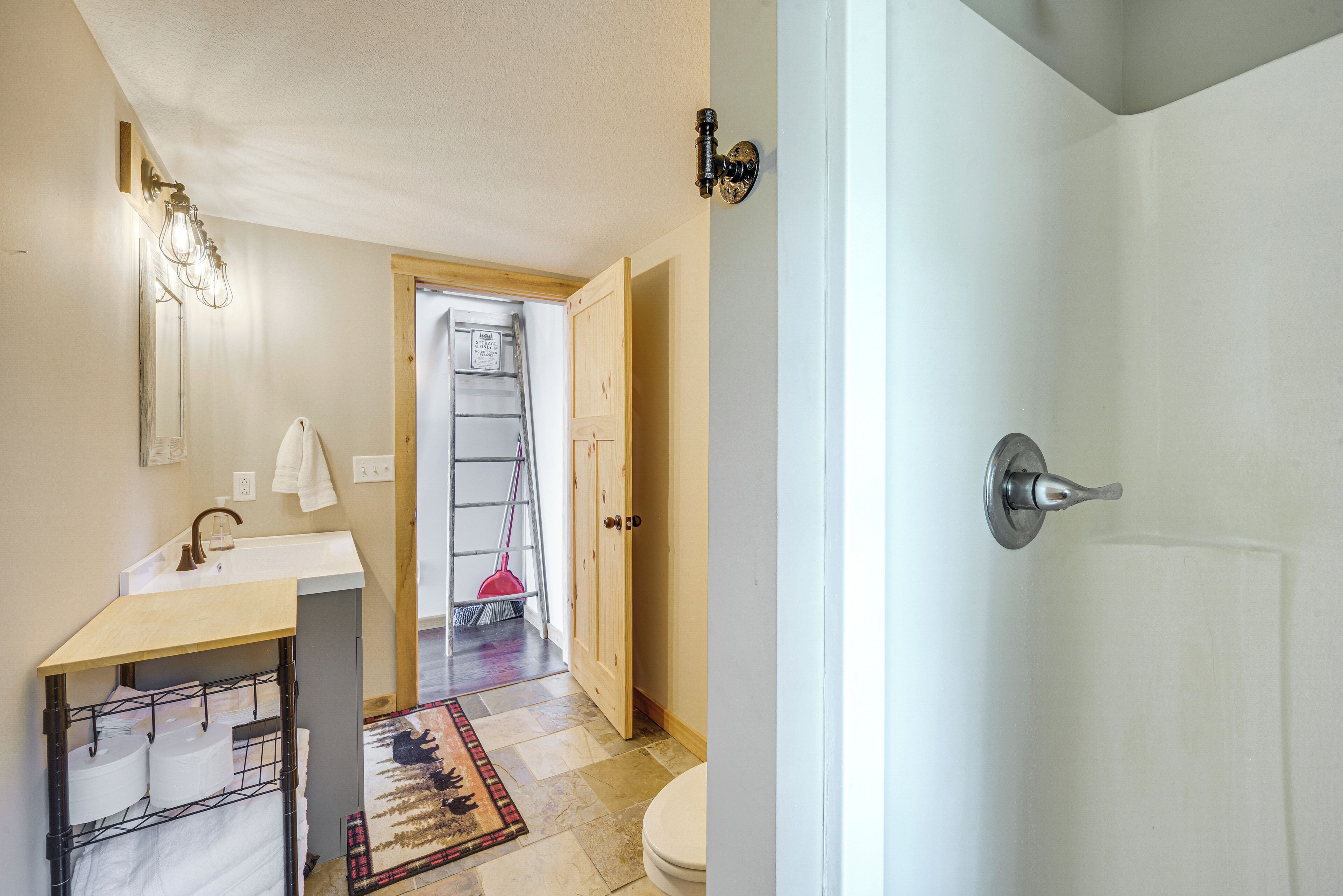 A bathroom with a toilet, sink, and a shower area.