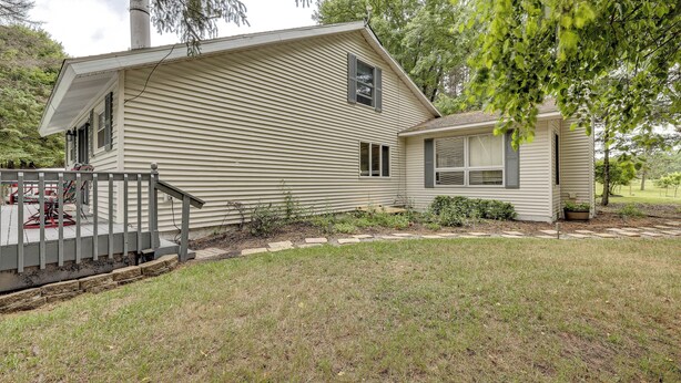 A single-story house with a front porch, a small attached garage, and a well-maintained lawn. - Game Room, Deck + Yard! Cadillac Family Escape (Cadillac)