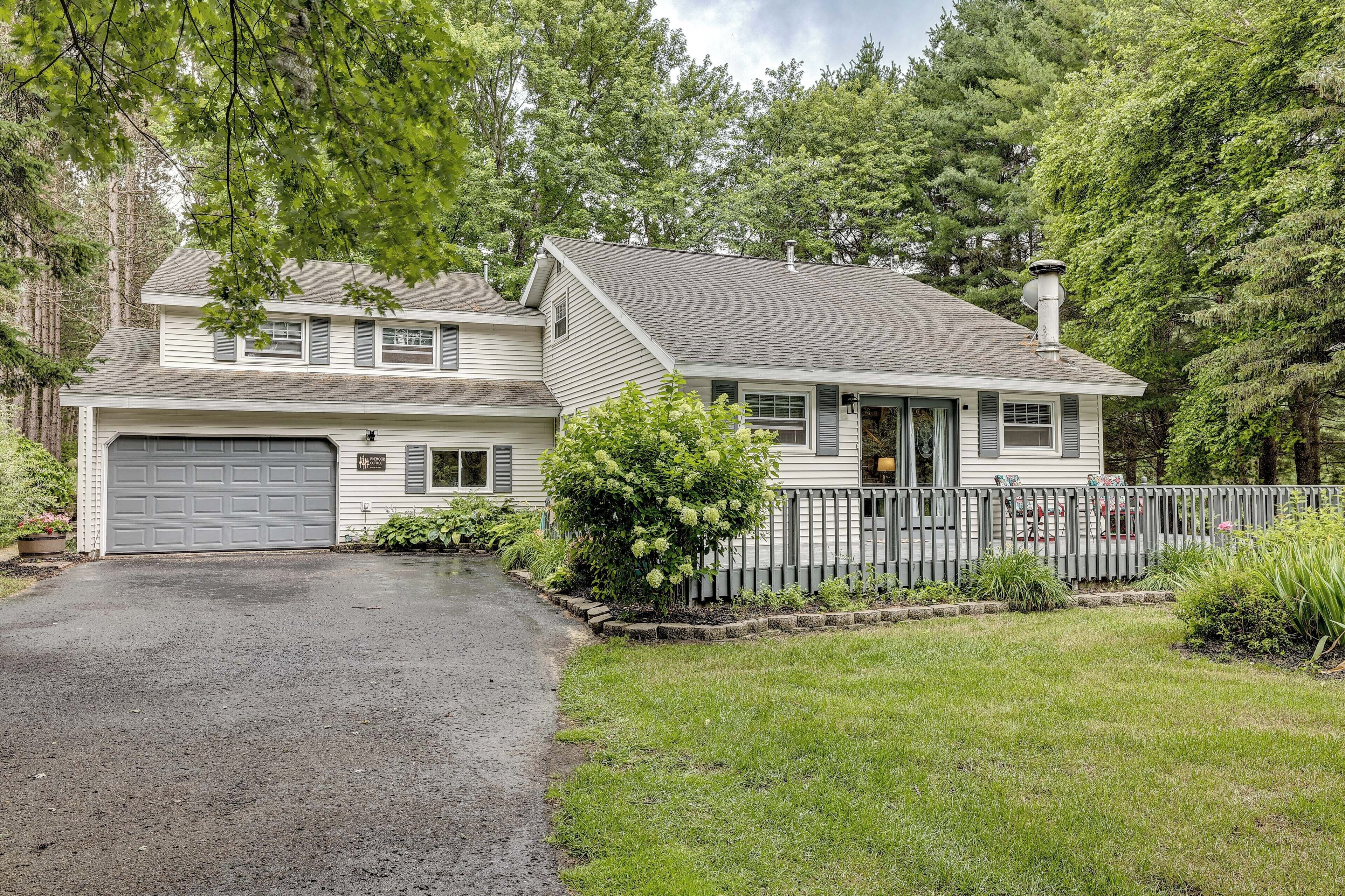 A two-story house with a garage, a fenced yard, and a driveway.