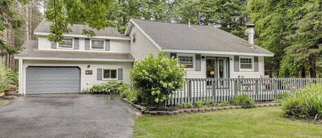A two-story house with a garage, a fenced yard, and a driveway.