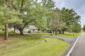 A residential street with houses, a driveway, and a road. - Game Room, Deck + Yard! Cadillac Family Escape (Cadillac)