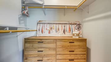 A wooden cabinet with drawers, a wall-mounted rack with clothes, and a shelf with a decorative item.