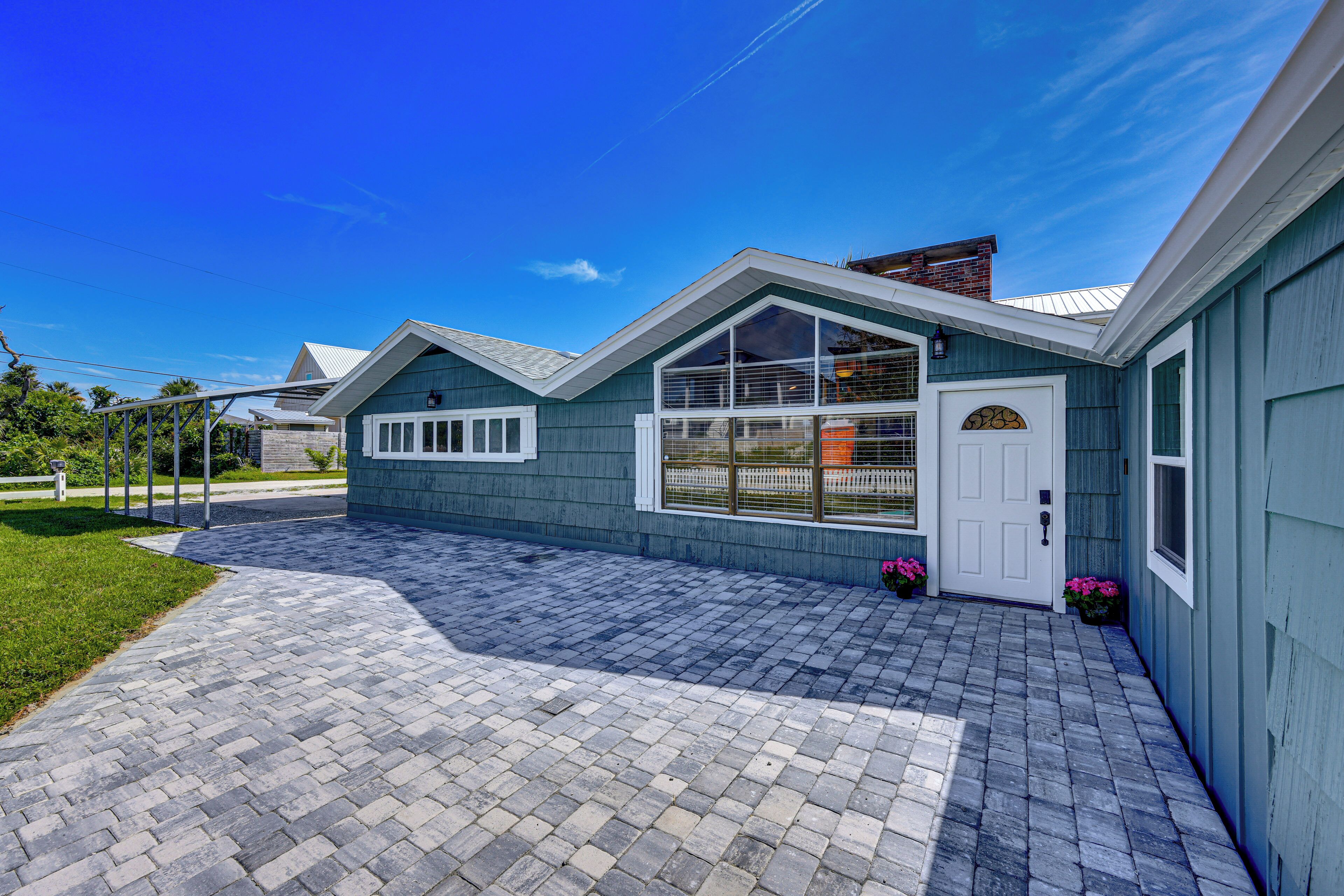 A residential house with a paved driveway, a front door, and a garage.
