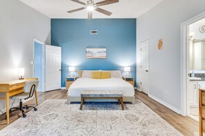 A bedroom with a bed, bedside tables, a desk, and a chair. - Pensacola Paradise - HTD Pool, Jacuzzi, Game Room (Pensacola)