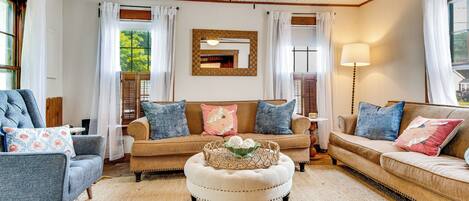 A cozy living room with a ceiling fan, a large mirror, and a lamp.