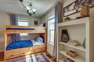 Una cama litera con un colchón azul, un cabecero de madera y una alfombra estampada.