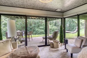 A modern interior with a glass door leading to a garden.