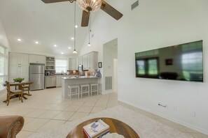 A spacious kitchen with a dining area, a ceiling fan, recessed lighting, and a large flat-screen TV mounted on the wall. - On 174 Acres! Ranch House in Colorado County (Weimar)