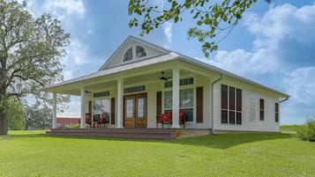 A two-story house with a porch, a covered front porch area, and a large front door.
