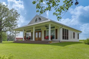A two-story house with a porch, a covered front porch area, and a large front door. - On 174 Acres! Ranch House in Colorado County (Weimar)